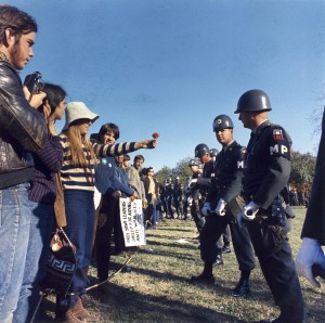 Pokojowy protest grupy hippisów po lewej przeciwko wojnie w Wietnamie, skierowany wobec służb mundurowych po prawej